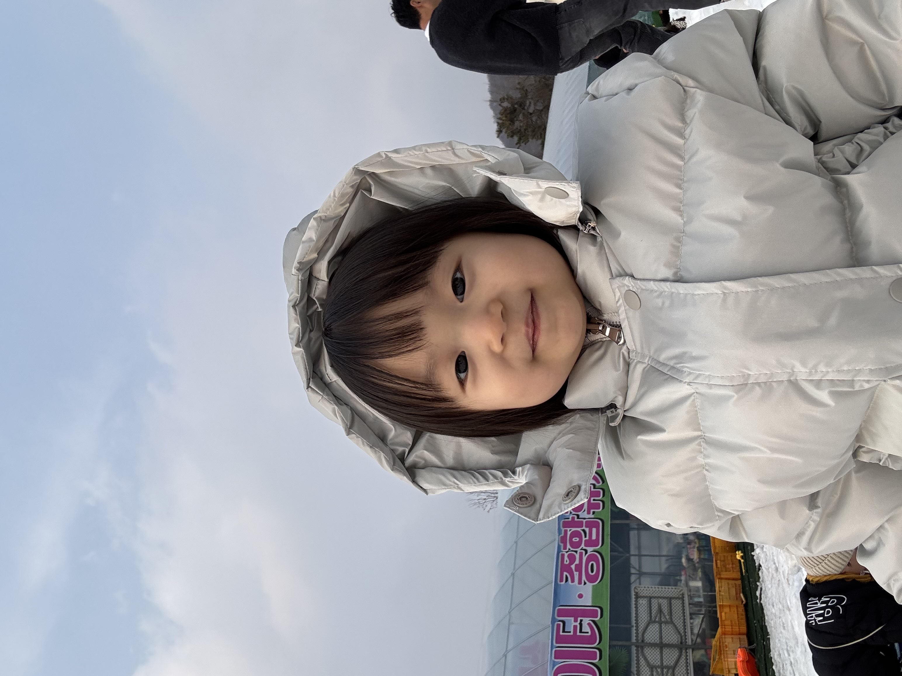 환하게 꾸며진 트리 앞에 서 있는 아이